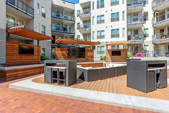 A modern outdoor seating area with a wooden deck and a television at Regatta Sloans Lake Apartments, Denver, Colorado